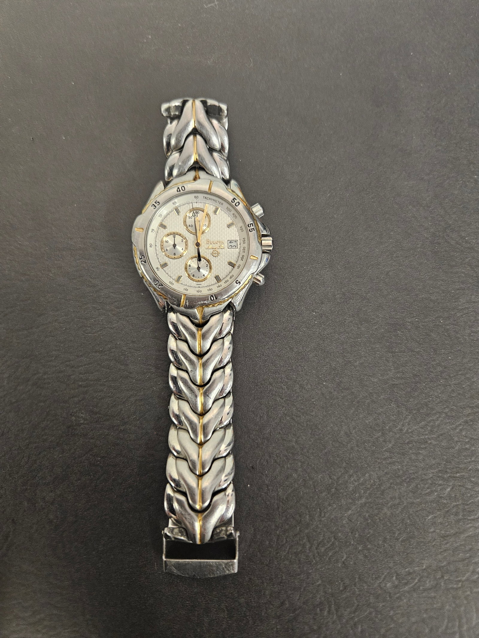 Bulova Marine Star Two-Tone Chronograph: This Bulova Marine Star chronograph watch features a textured white dial with three sub-dials and a date window at the 4 o'clock position. The two-tone stainless steel case is paired with a