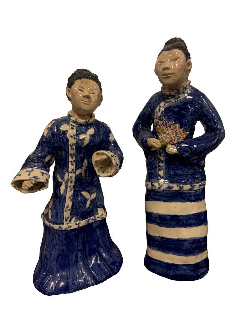 Pair of Studio Pottery Blue & White Figu: This pair of hand-built ceramic figurines depicts two figures in traditional Chinese-style robes decorated with blue and white glazes. The larger figure holds a colorful fan, while both feature