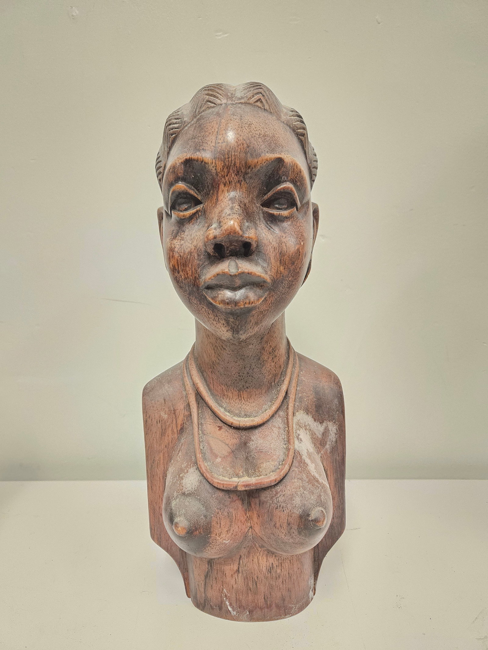 Large Hand-Carved African Style Wood Bus: An impressive hand-carved hardwood bust of a woman, rendered in a traditional African style with intricate braided hair and jewelry. The sculpture features a dark stain finish that highlights the