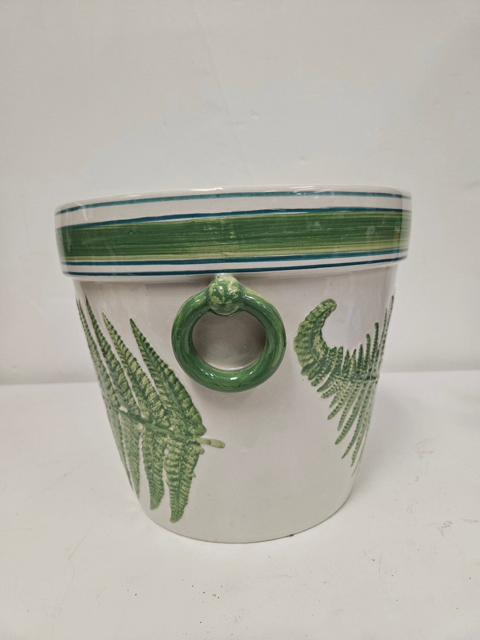 Large Mottahedeh Hand Painted Planter: Large ceramic planter featuring a hand-painted fern leaf design in shades of green set against a white glaze. The piece is accented by a banded rim and two decorative green ring handles on the sides.