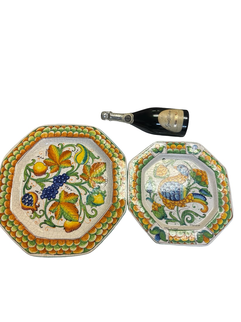 Pr. Hand-Painted Italian Majolica Plates: This set includes two octagonal majolica platters featuring hand-painted designs of a peacock and harvest fruits. Each piece is decorated with a vibrant scalloped border in orange and green, bearing t