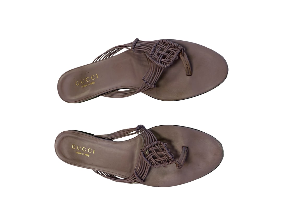 Gucci Woven Lavender Leather Sanda: These lavender sandals feature an intricate woven leather strap design in a thong-style silhouette. The flat footbeds are marked with a gold-tone brand logo and 'Made in Italy' stamp. A minimalist lea