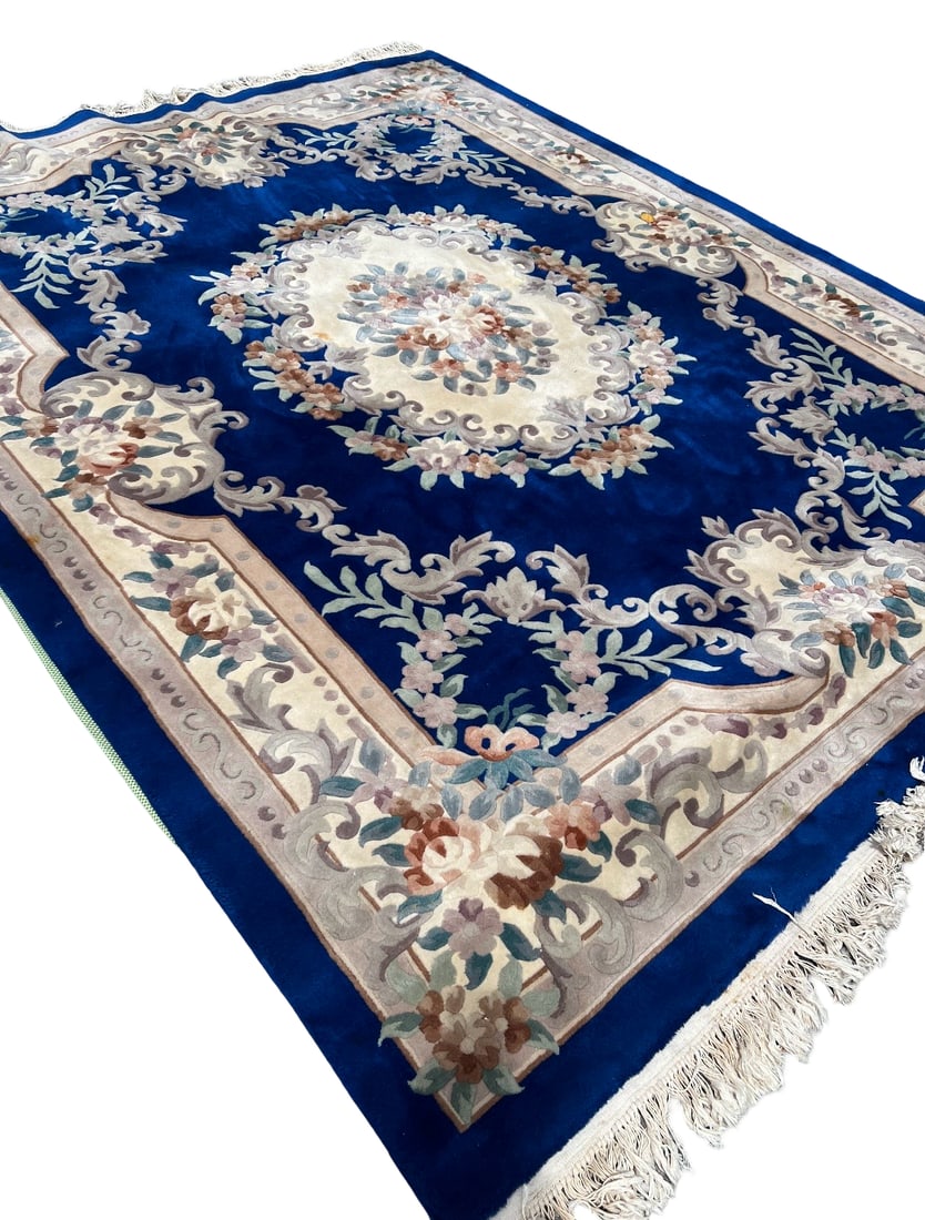 Blue Chinese Aubusson Style Floral Wool: This Chinese Aubusson style area rug features a vibrant royal blue field decorated with a central floral medallion. The ornate design includes scrolling acanthus leaves and pastel floral motifs throug