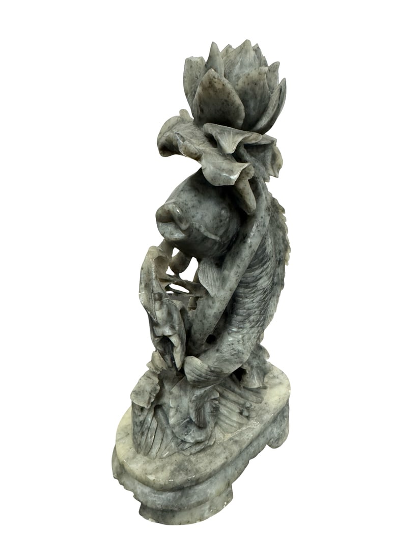Carved Soapstone Koi Fish and Lotus Scul: A detailed Chinese-style hand-carved soapstone sculpture depicting a koi fish leaping alongside a lotus blossom. The piece features a mottled gray and cream stone with intricate openwork carving on an