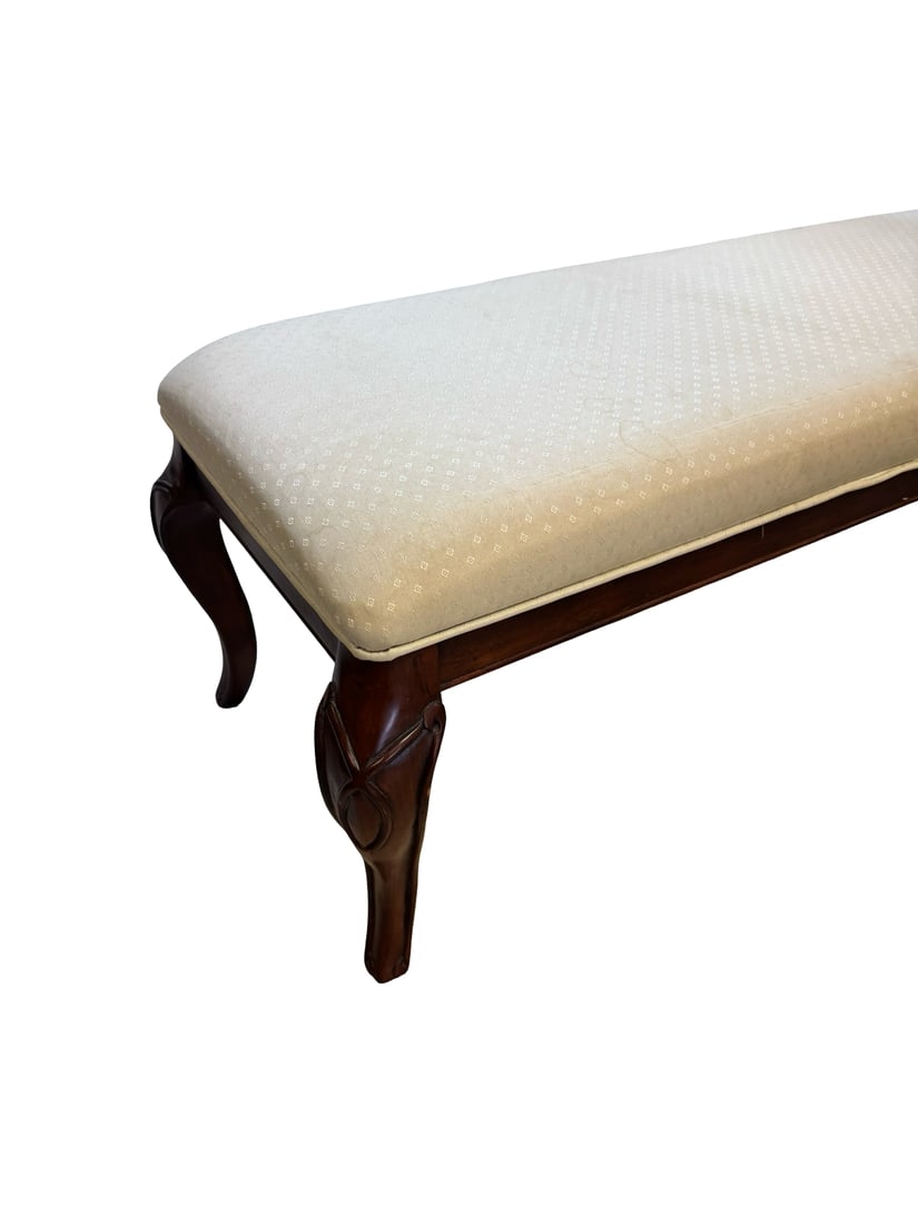 Vintage Traditional Upholstered Bench: This upholstered bench features a cream-colored fabric with a subtle geometric diamond pattern. It is supported by four dark-stained wooden cabriole legs with decorative carved floral-style accents. T