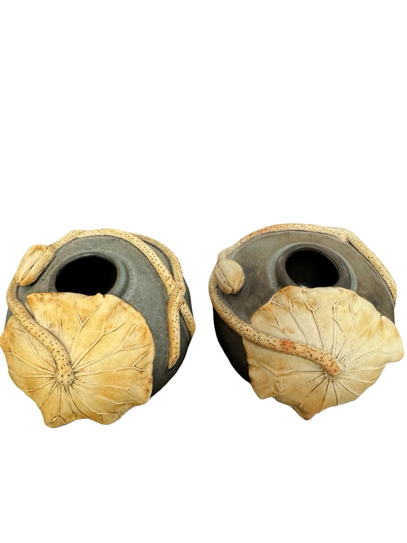 Pair of Studio Pottery Lotus Leaf Vases: This pair of contemporary studio pottery vessels features a rich charcoal-grey glaze with a textured matte finish. Each orb-shaped pot is adorned with intricate hand-modeled lotus motifs, including sp