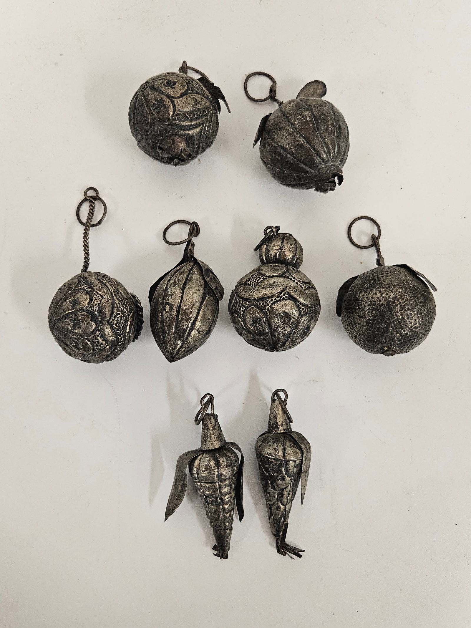 8pc Vintage Style Metal Fruit Ornaments: This collection features eight vintage-style fruit-themed ornaments crafted from pressed and textured metal with an aged silver-tone finish. The set includes a variety of forms such as pomegranates, c