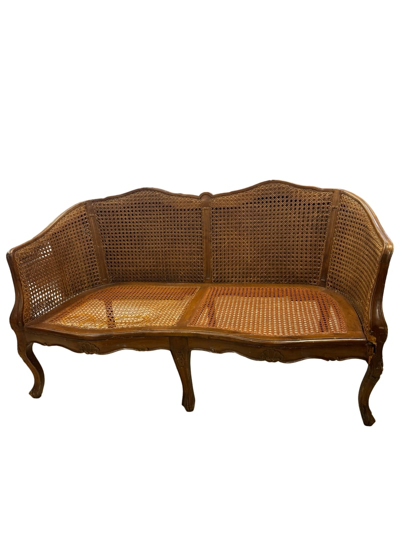 French Provincial Style Cane Settee: This French Provincial style settee features an elegant wood frame and traditional woven cane back and seat panels. The piece is designed with a serpentine front and cabriole legs, showcasing classic 