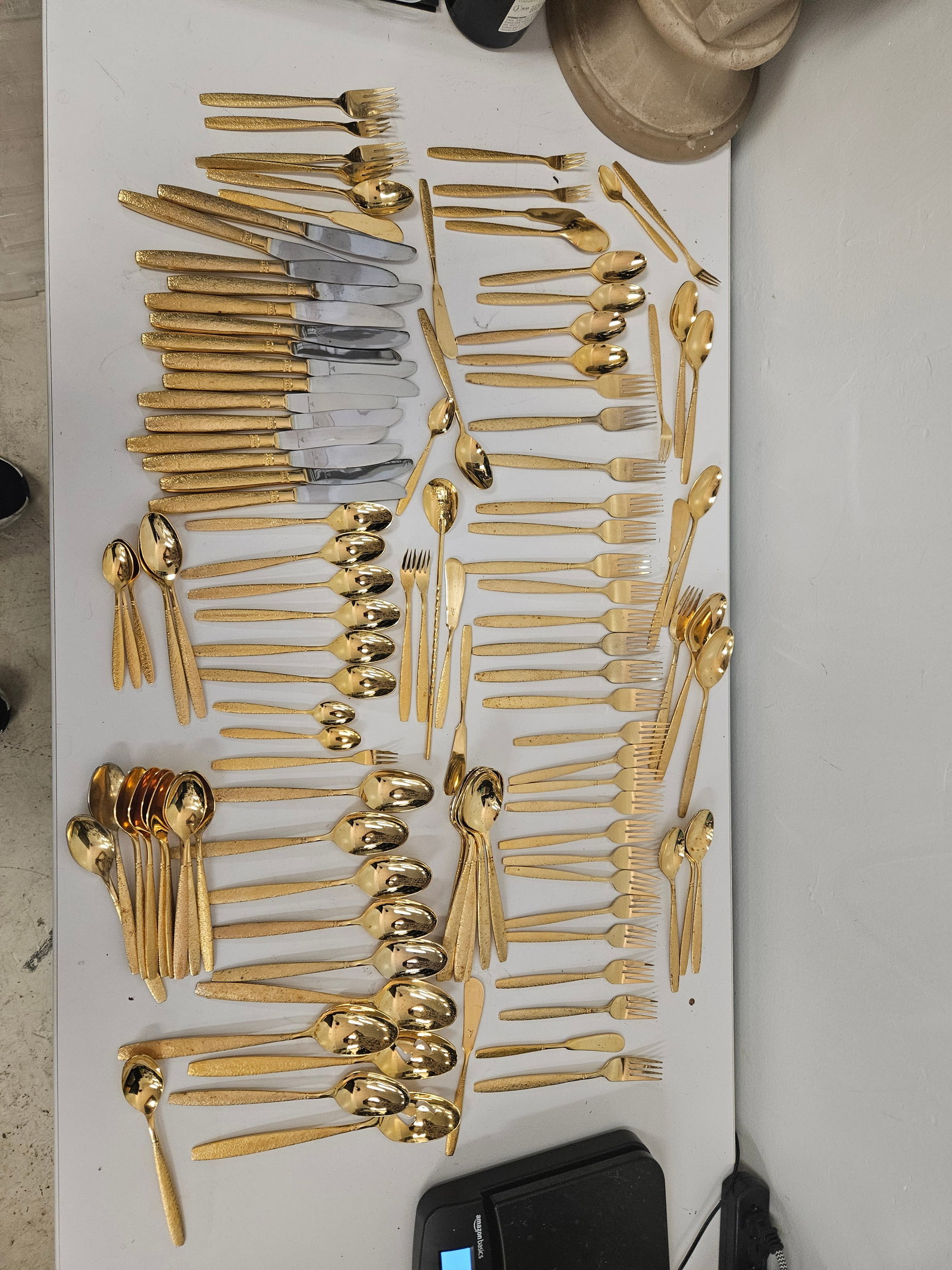 88 Large VG Gold-Tone Bark Flatware: This expansive vintage gold-tone flatware service features a distinctive textured 'bark' or Florentine finish on the handles. The set includes a comprehensive assortment of forks, spoons, and knives, 