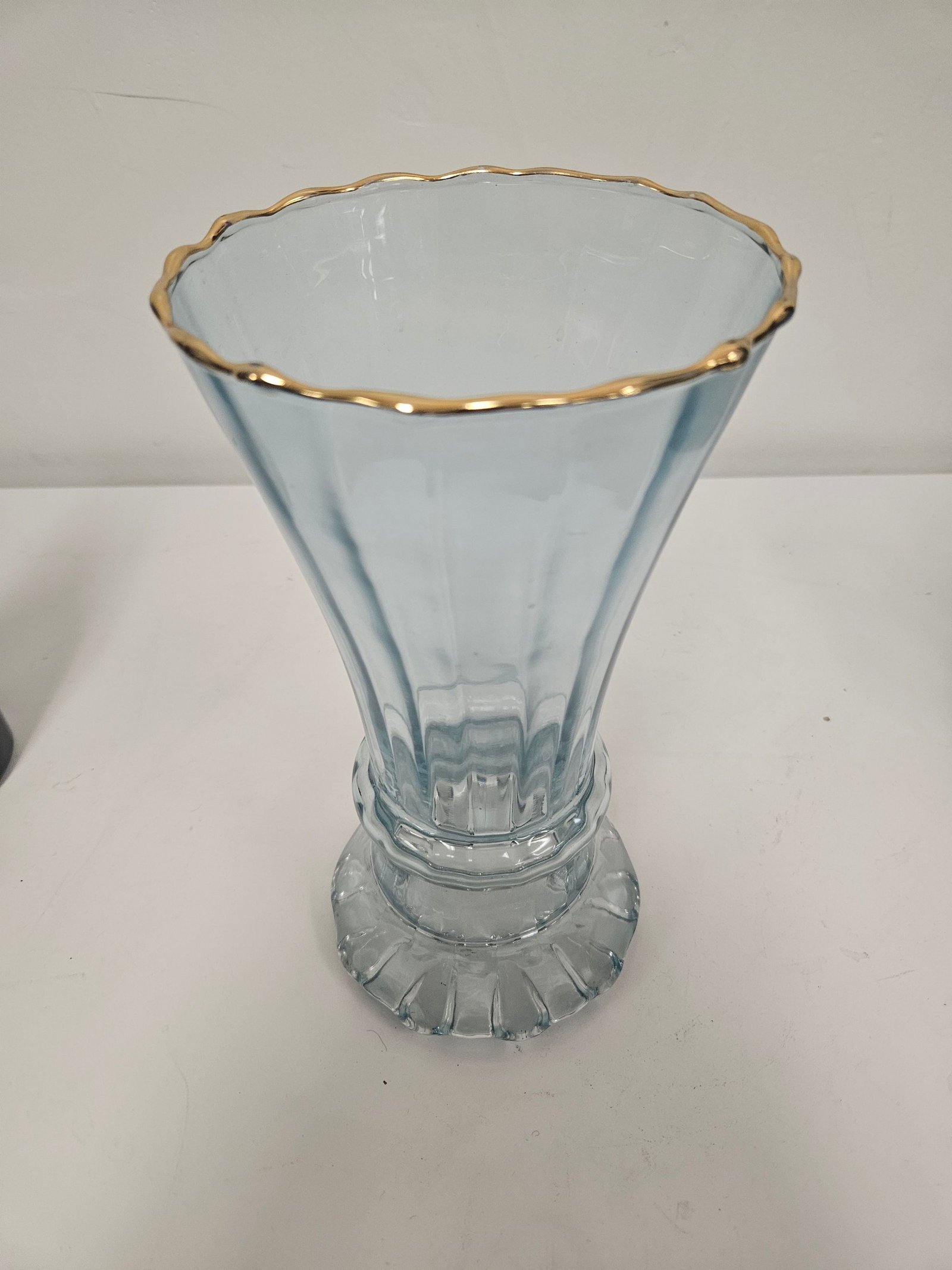 Vintage Blue Ribbed Glass Trumpet Vase: This elegant pale blue glass vase features a classic trumpet silhouette with a graceful flared rim. A gilded gold-tone band accents the scalloped top edge, complementing the soft pastel hue of the gla