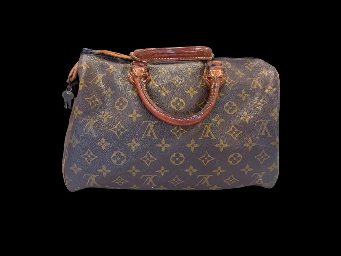 Vintage Louis Vuitton Style Speedy Bag: This handbag features the classic LV monogram pattern on coated canvas with natural vachetta leather trim. The silhouette follows the traditional Speedy 30 design, featuring dual rolled top handles