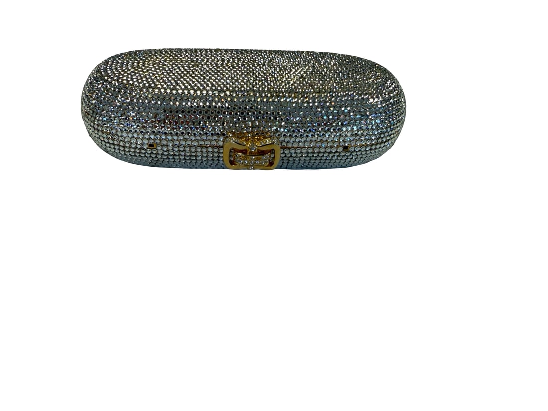 Crystal Encrusted Minaudiere Clutch: This elegant evening clutch is fully encrusted with shimmering clear crystals in a pill-box silhouette. The gold-tone frame features a bow-shaped clasp adorned with additional crystal accents and open