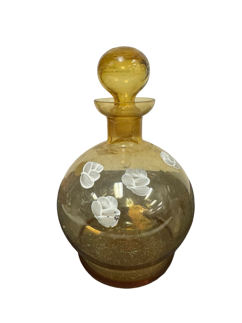 Vintage Amber Glass Hand-Painted Floral: This vintage glass decanter features an amber-tinted body with a bulbous silhouette and a matching round stopper. The exterior is decorated with hand-painted white floral motifs that add a charming fo