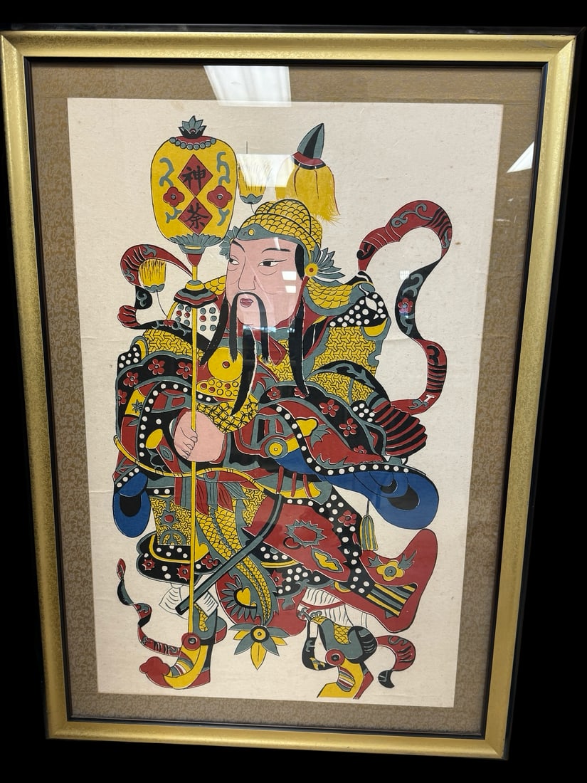 Framed Chinese Woodblock Door God Print: This framed Chinese woodblock print depicts a vibrant Door God (Men Shen) dressed in elaborate traditional military armor and holding a ceremonial staff. The artwork features a bold palette of red, ye