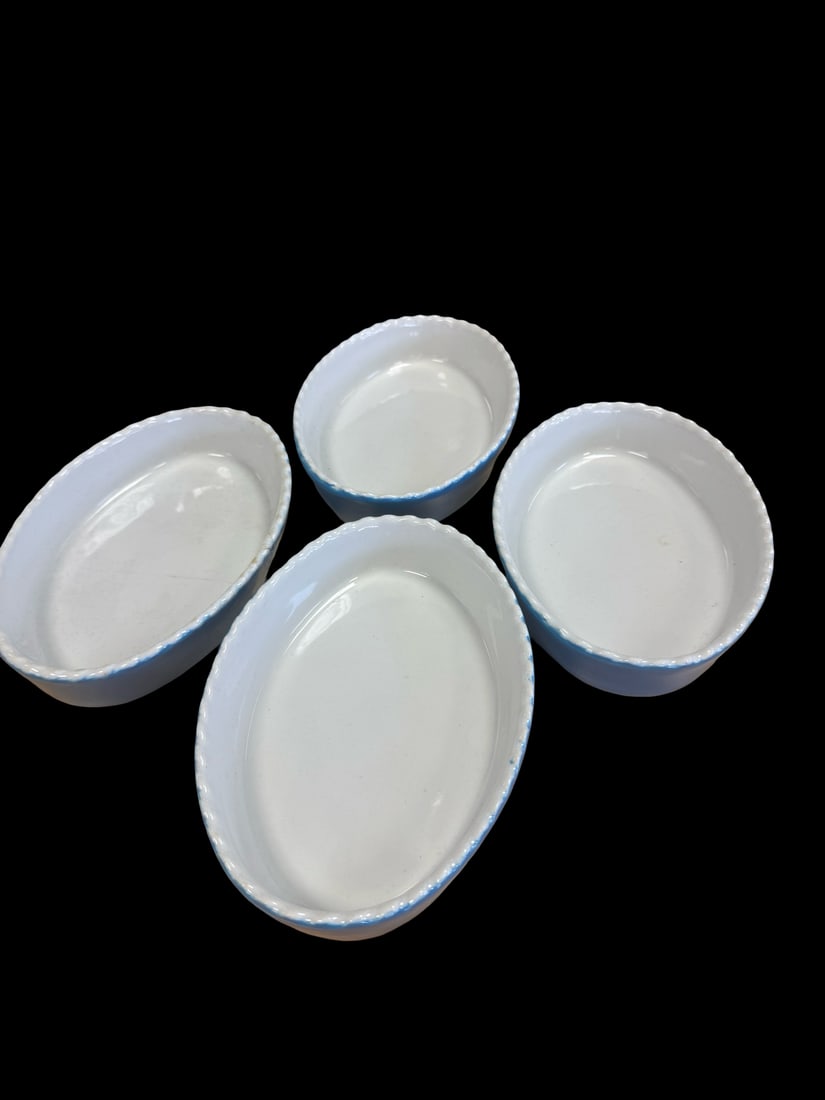Set of 4 Vintage Blue Scalloped Bakers: This set of four oval ceramic baking or gratin dishes features a white glazed interior and vibrant blue exterior. Each piece is finished with a charming scalloped rim highlighted by a blue dotted bord