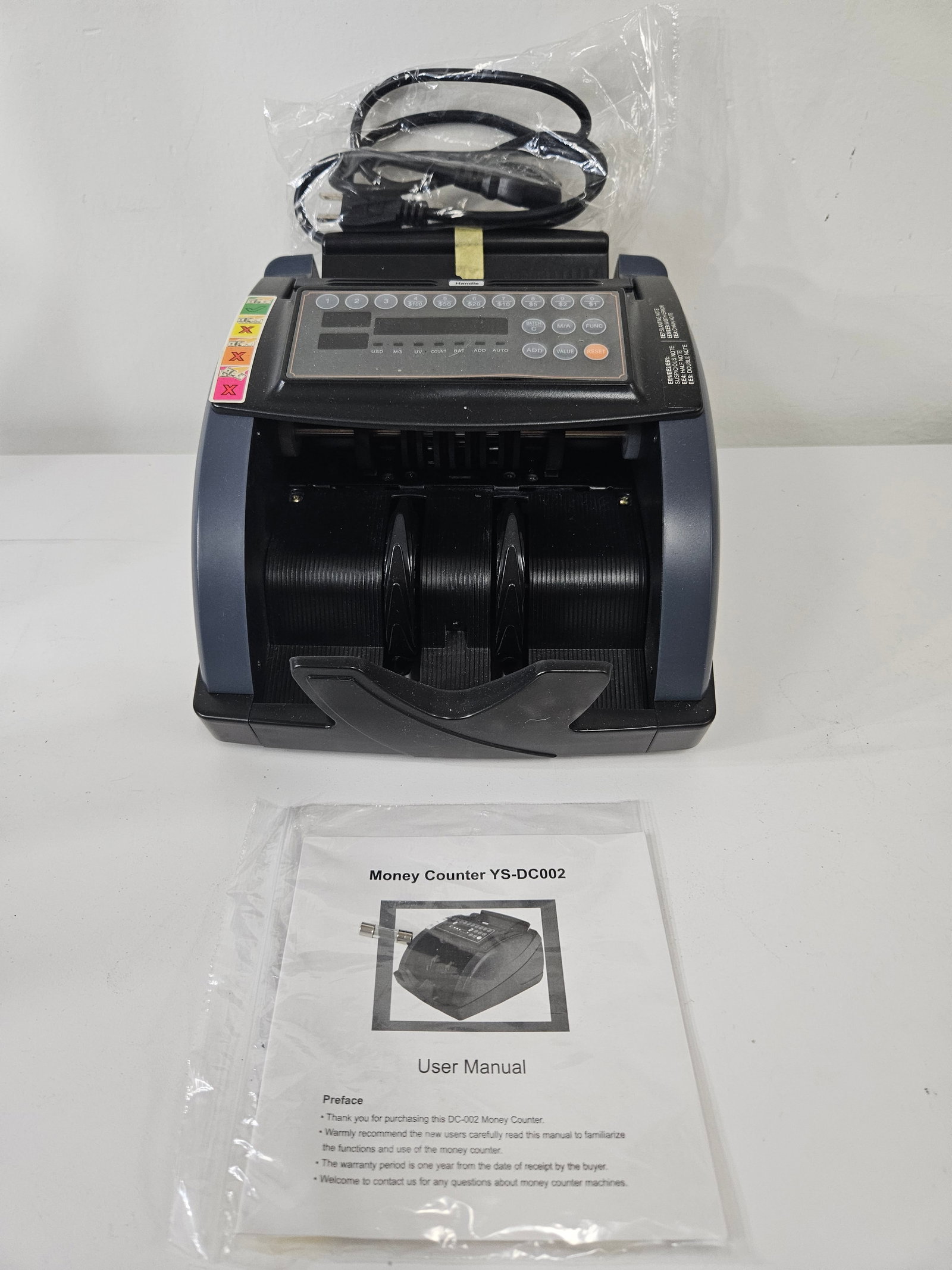Digital Money Counter Model YS-DC002: This digital money counter, model YS-DC002, features an integrated keypad for batching and value counting of various currency denominations. The unit appears to be constructed of durable plastic with