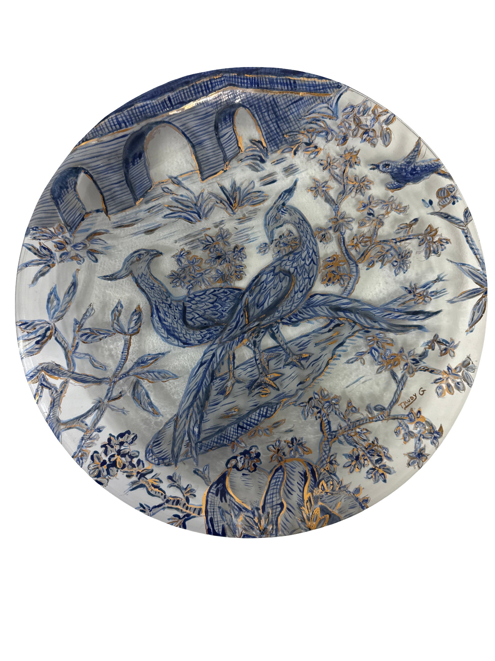 Trudy G. Artist Signed Peacock Charger: Large hand-painted glass charger featuring a detailed scene of two peacocks in a floral landscape with an arched bridge in the background. The artwork is executed in a reverse-painted style using