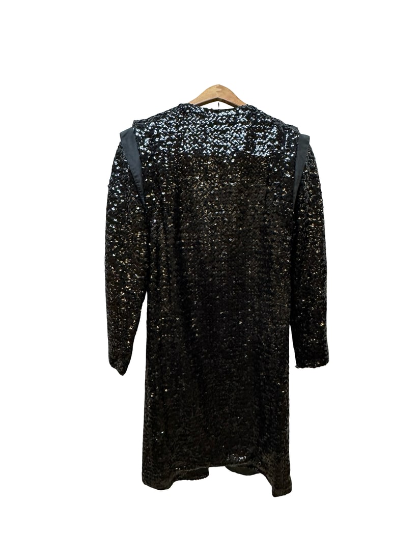 Vintage Basile Black Sequin Evening Coat: This vintage Basile evening coat features an open front design covered in shimmering black sequins with iridescent undertones. The garment is characterized by dramatic shoulder detailing with