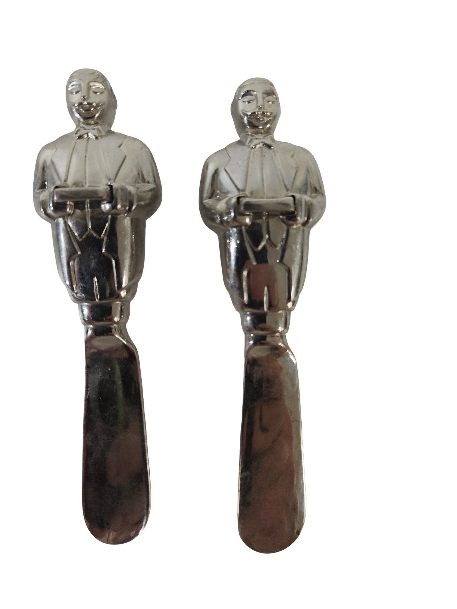 Pair of Lenox Butler Figural Spreaders: A pair of silver-tone cheese or butter spreaders featuring figural handles shaped like tuxedo-clad butlers. Each piece is marked with the Lenox name on the reverse of the blade. These whimsical