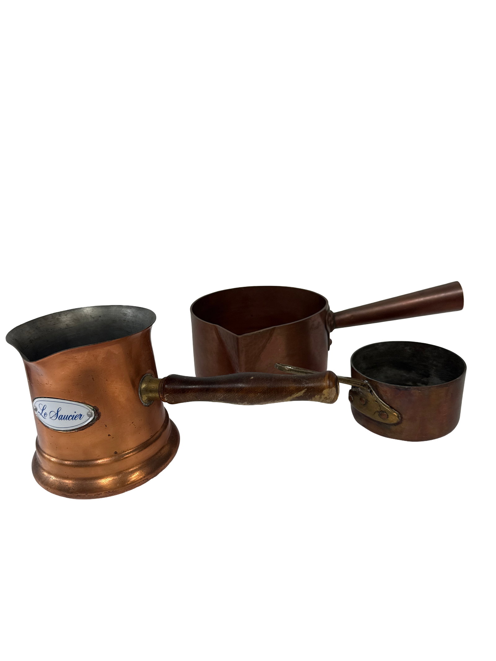Vintage 3-Piece Le Saucier Copper Set: This three-piece set of vintage copper cookware includes two saucepans and a tall coffee pot or pourer. The larger pot features a classic silhouette with a wooden handle and is labeled with a medallio