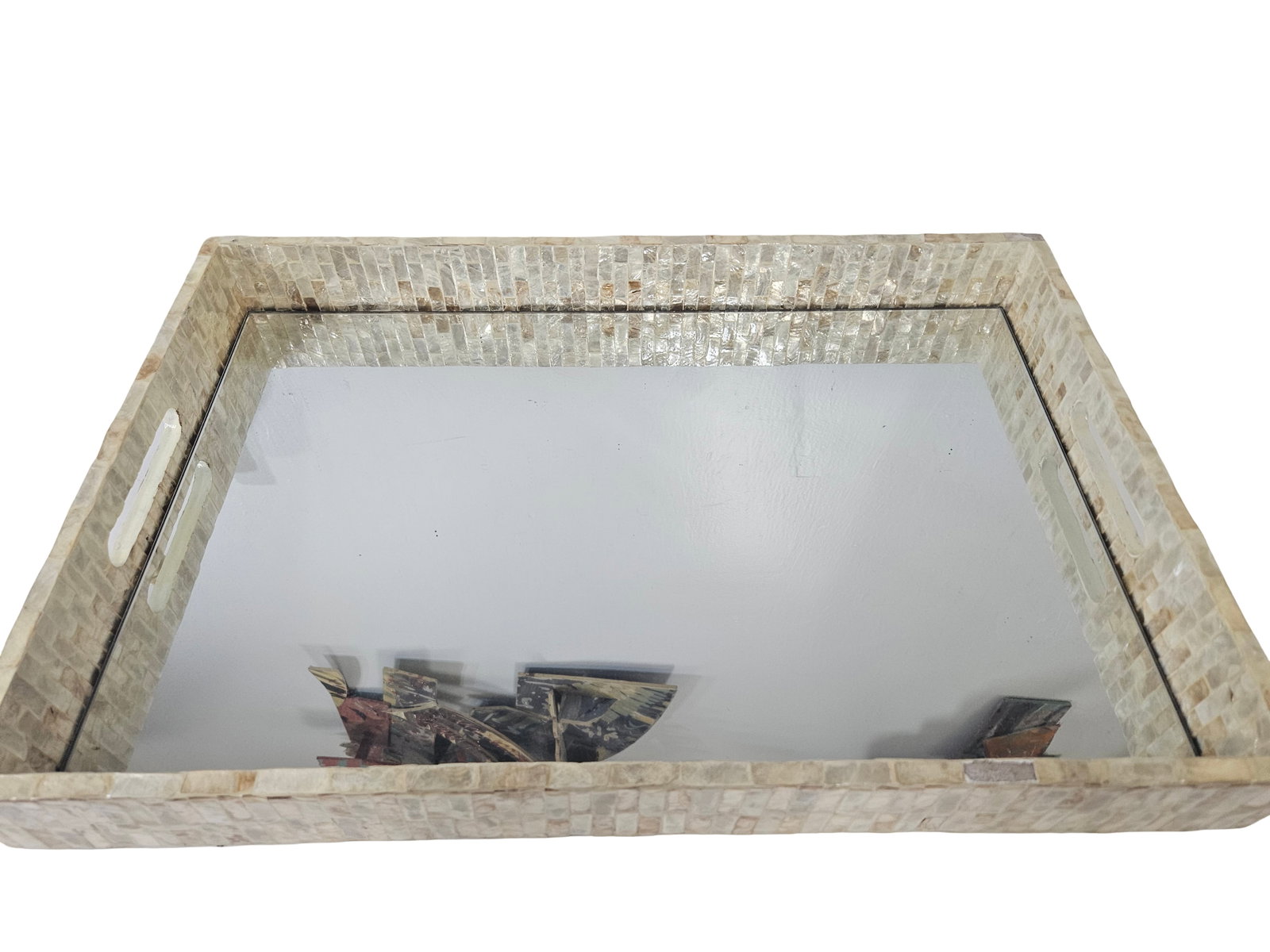Mother of Pearl Mirrored Vanity Tray: This rectangular vanity tray features a decorative frame composed of iridiscent mother of pearl or shell mosaic tiles. The center is fitted with a mirrored base, creating an elegant surface for