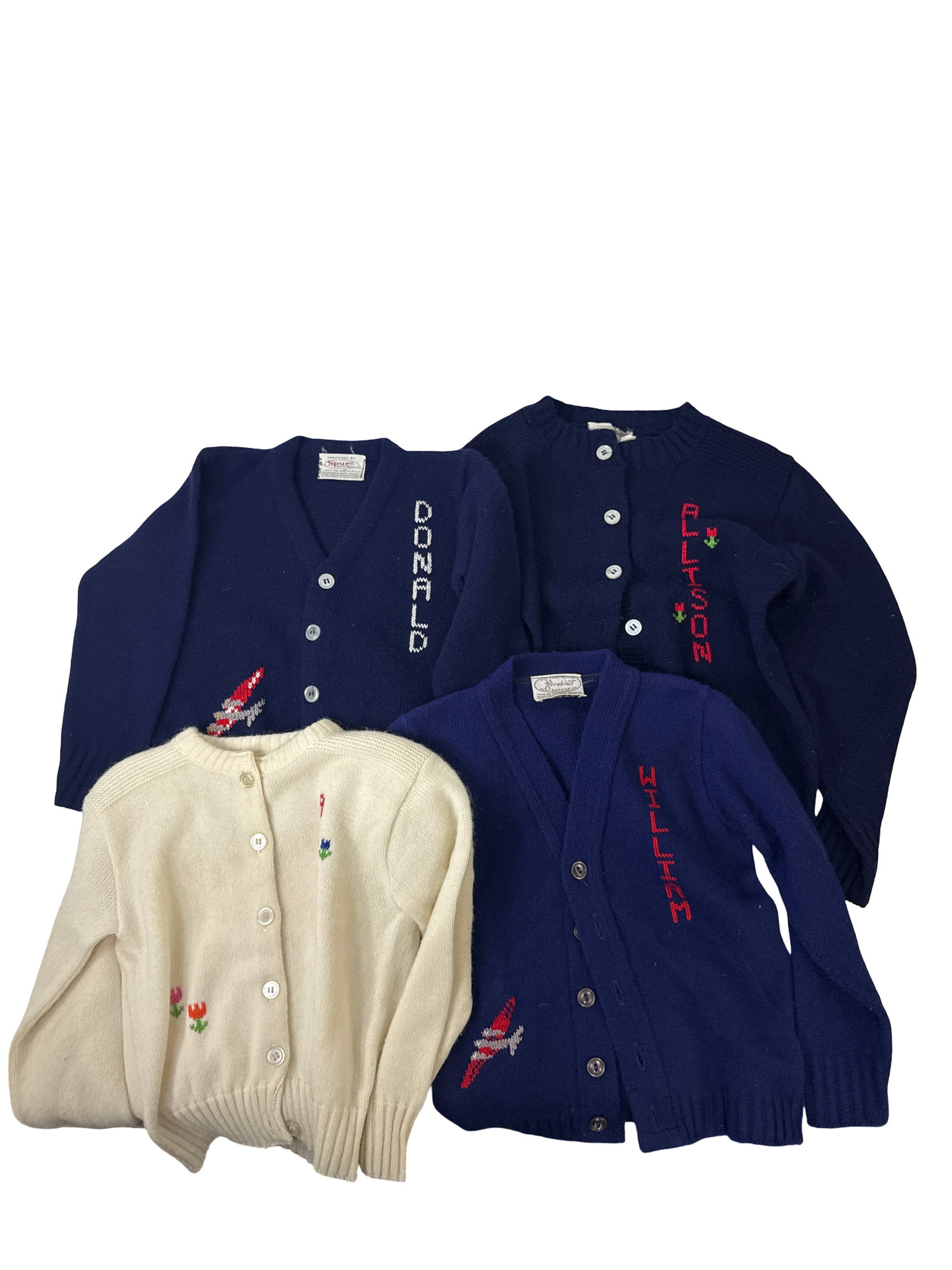 4 Vintage Personalized Child Cardigans: This lot features four vintage children's cardigans, including three navy blue and one cream-colored sweater. Each piece is decorated with personalized names like 'Donald' and 'Allison' along with sma
