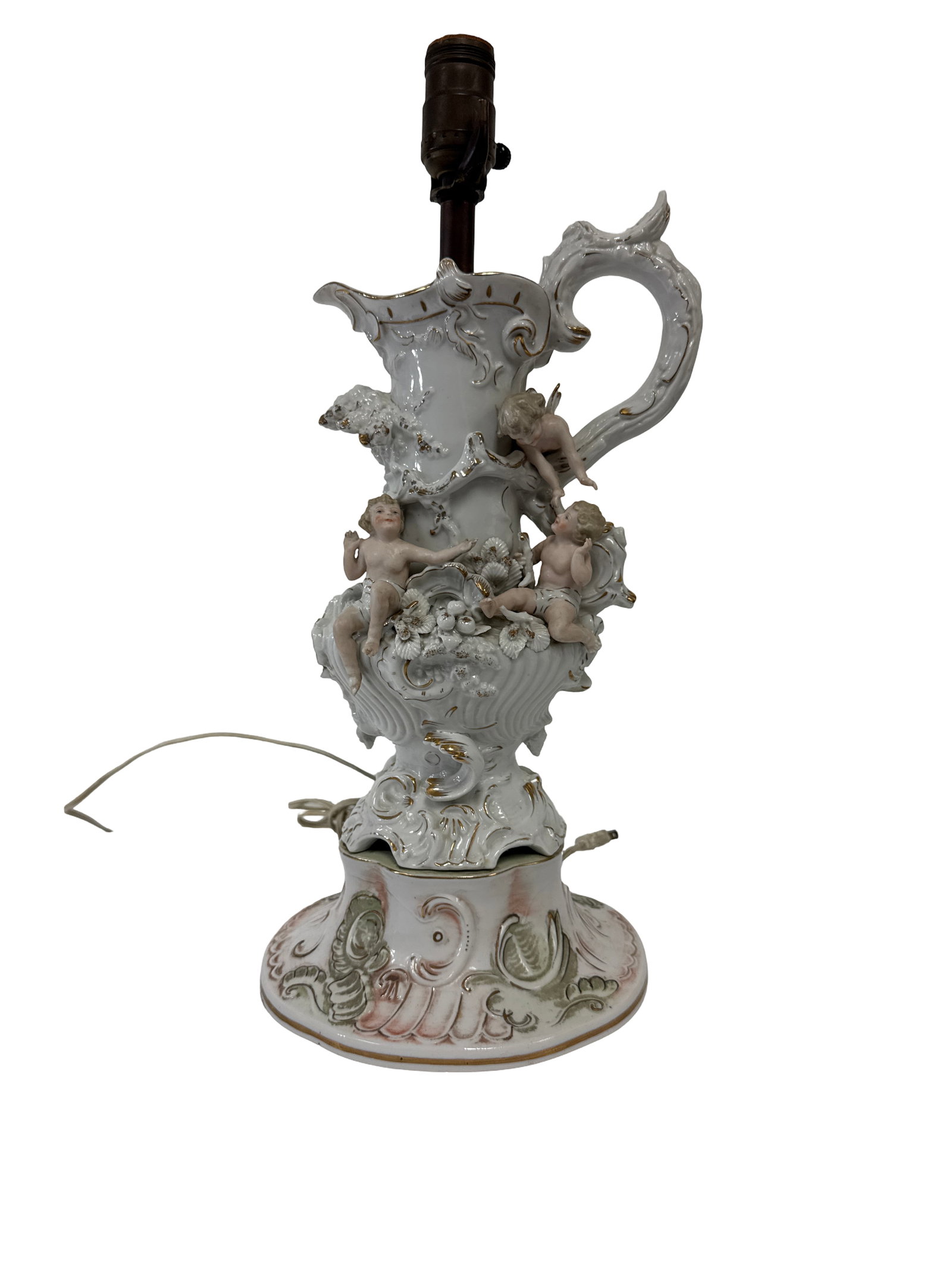 Porcelain Cherub and Floral Ewer Lamp: This ornate porcelain lamp features a decorative ewer-form base adorned with three dimensional cherub figures and encrusted floral details. The piece is finished with a white glaze highlighted by