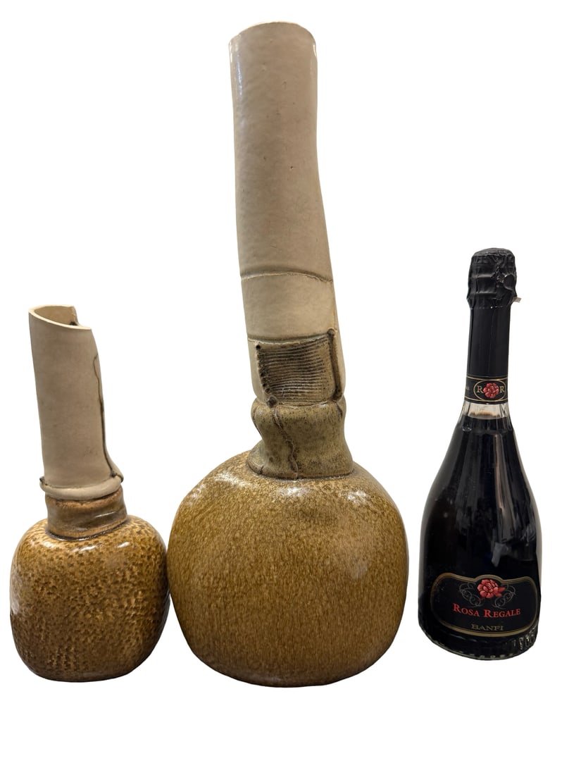 Pr. Signed Baldwin Studio Pottery Vases: This pair of studio pottery vessels features a distinct two-toned finish with bulbous glazed bases and elongated matte necks. The larger piece displays a textured, ribbed collar and a slightly curved 
