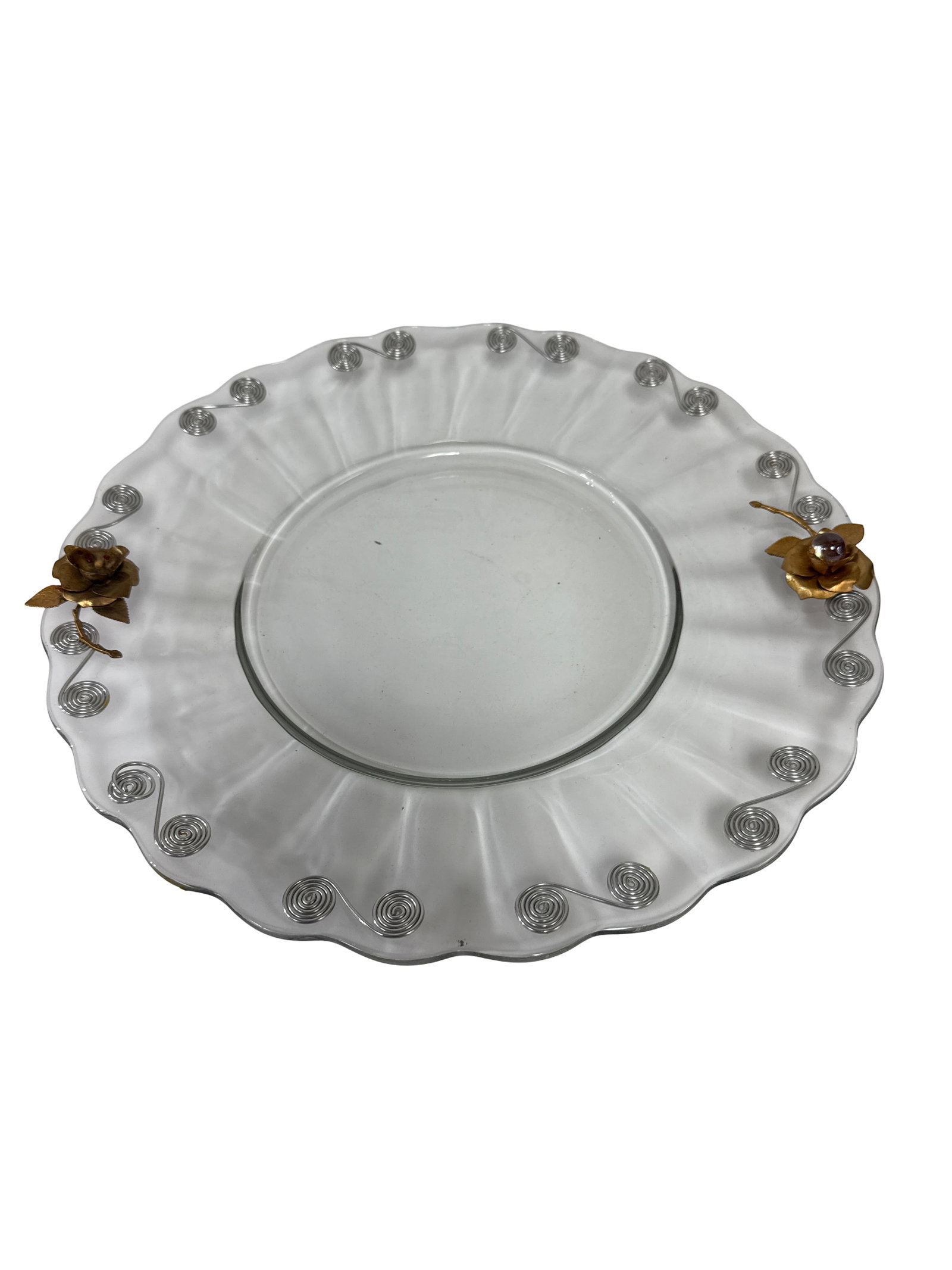 Glass Platter with Metal Rose Accents: Large clear glass serving platter featuring a scalloped rim and radial textured ribbing. The piece is embellished with a decorative silver-tone wire spiral border and two applied gold-tone metal rose 