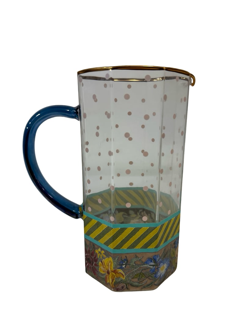 MacKenzie-Childs Aurora Glass Pitcher: This MacKenzie-Childs Aurora glass pitcher features a charming multi-pattern design including floral motifs, stripes, and pink polka dots. It is crafted with a distinctive octagonal body, a blue glass