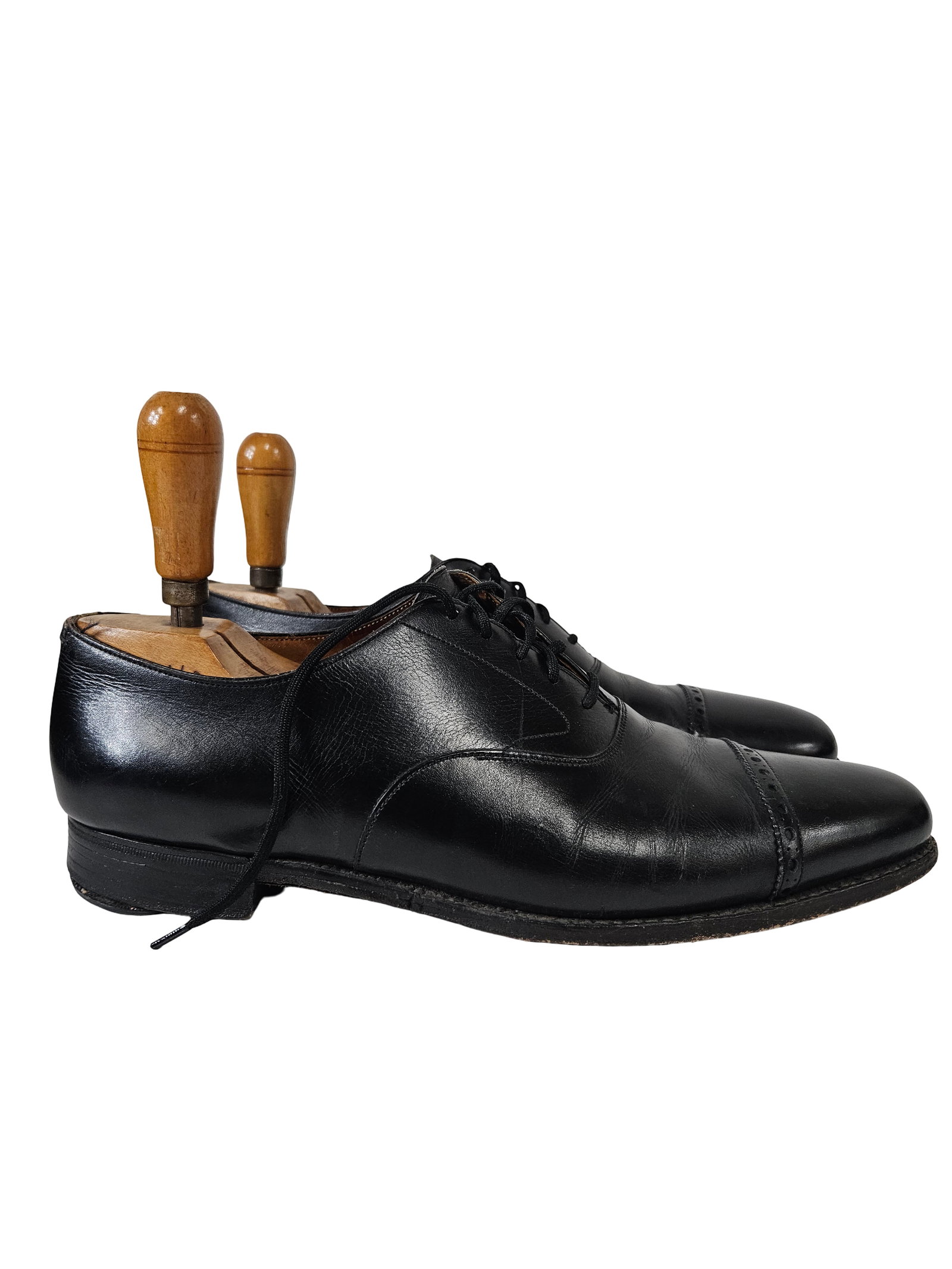 Men's Black Leather Cap Toe Oxfords: A pair of classic men's black leather oxford dress shoes featuring a cap toe with decorative brogue detailing. These shoes are constructed with a traditional lace-up closure and include a pair of
