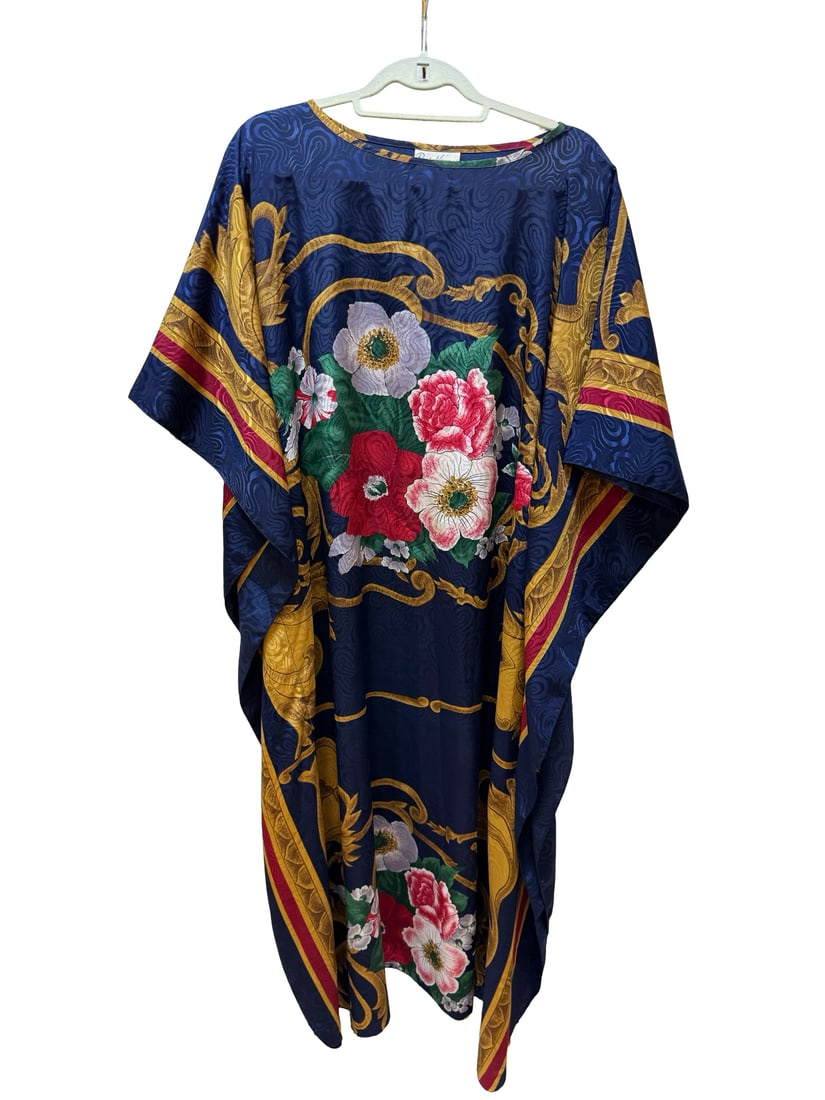 Ruth Norman Vintage Floral Kaftan Gown: This elegant vintage kaftan by Ruth Norman New York features a rich navy blue damask-textured base adorned with a large central floral motif. The design includes bold scrolled golden borders and vibra