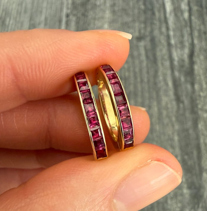 Pair of Channel Set Ruby Charm Holders or Clasps: A pair of elegant 14K gold clasps featuring channel-set rubies for holding charms.