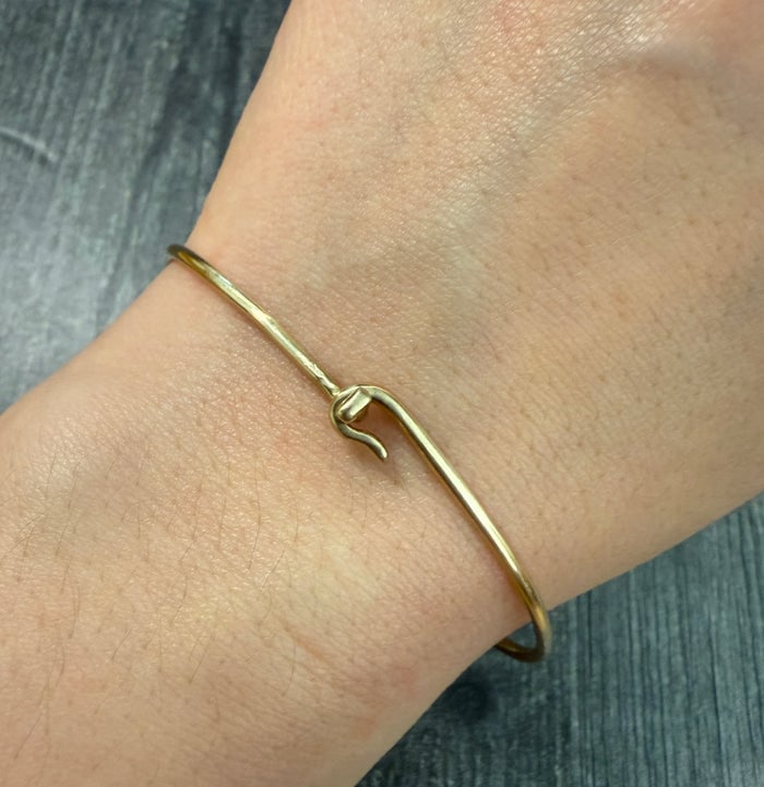 Vintage 14K Gold Ball and Hook Wire Bangle Bracelet: A 14K gold wire bangle accented with gold ball terminals and a hook closure.