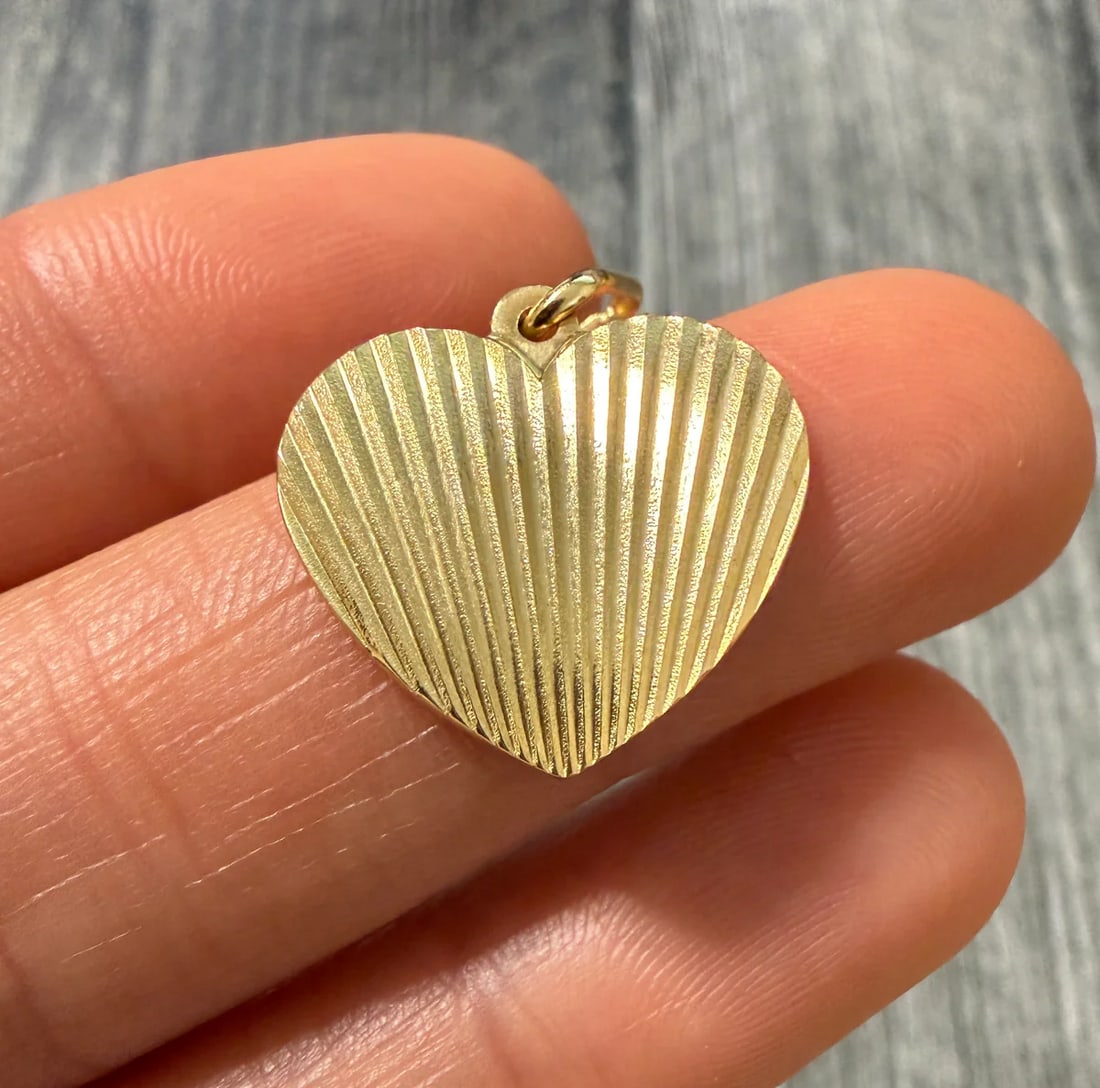Engine Turned 14K Gold Heart Charm: Metal: 14K Yellow Gold Weight: 3 gramsMeasurements: 0.7 inches long by 0.75 inches wideMarkings: "14KT ITALY"Condition: In very good condition with only minor surface wear.