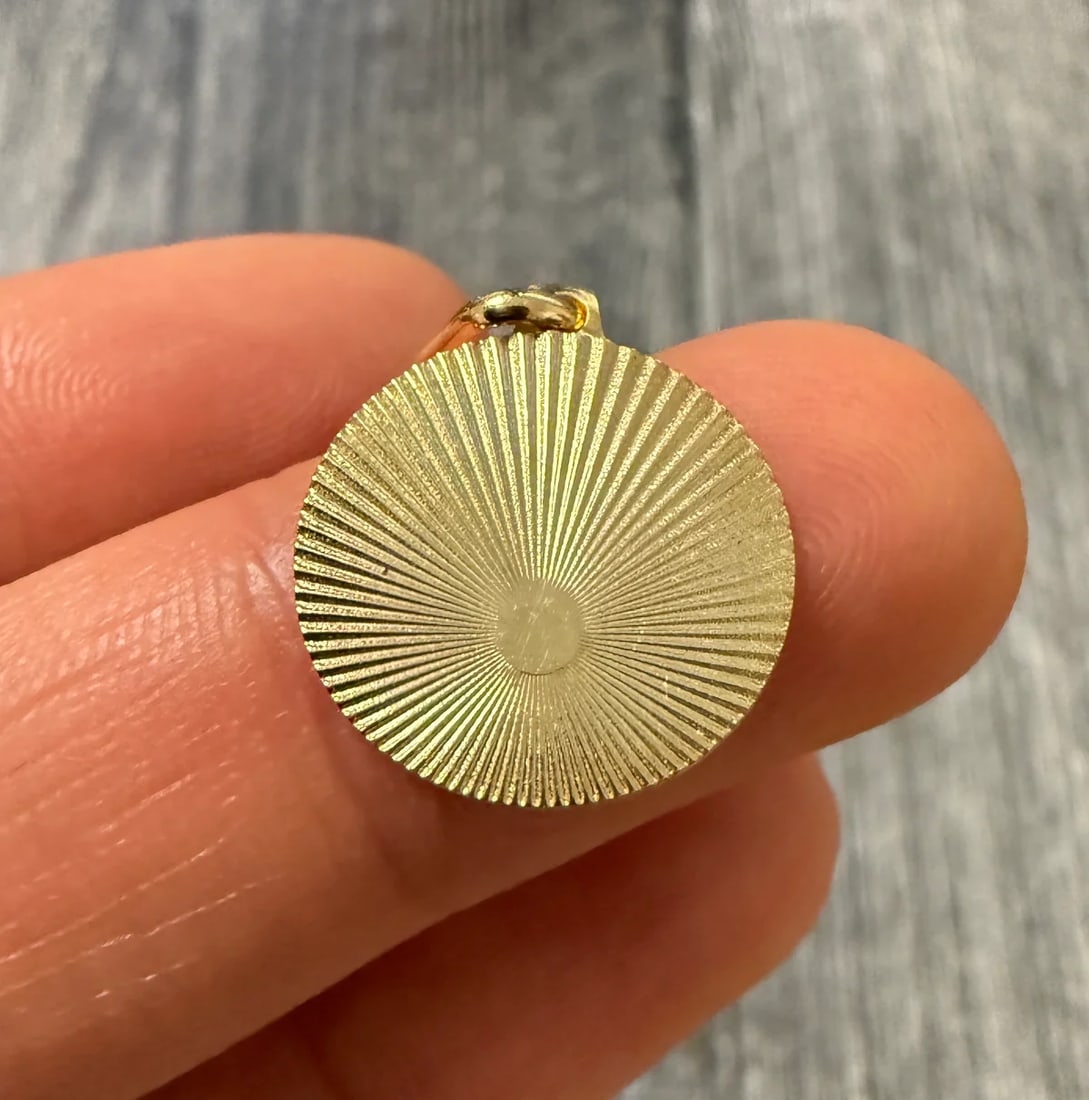 Engine Turned 14K Gold Disc Charm: Metal: 14K Yellow Gold Weight: 1.4 gramsMeasurements: 0.65 inch diameter Markings: "14KT ITALY"Condition: In very good condition with only minor surface wear.