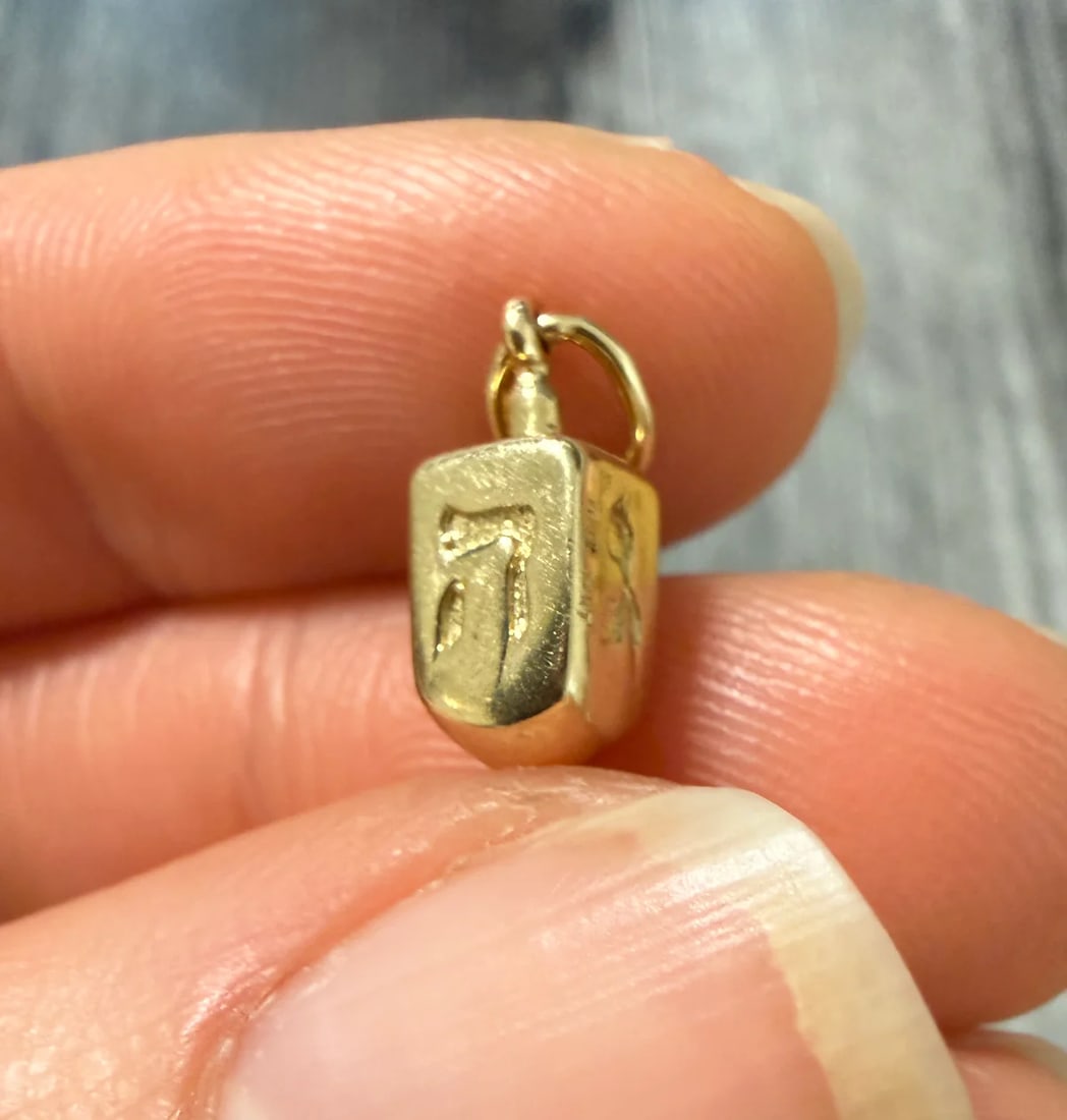 Mini 14K Gold Dreidel Charm: Metal: 14K Yellow Gold Weight: 1.8 gramsMeasurements: 0.45 inches long by 0.2 inches wideMarkings: "ITALY 14KT"Condition: In very good condition with only minor surface wear.