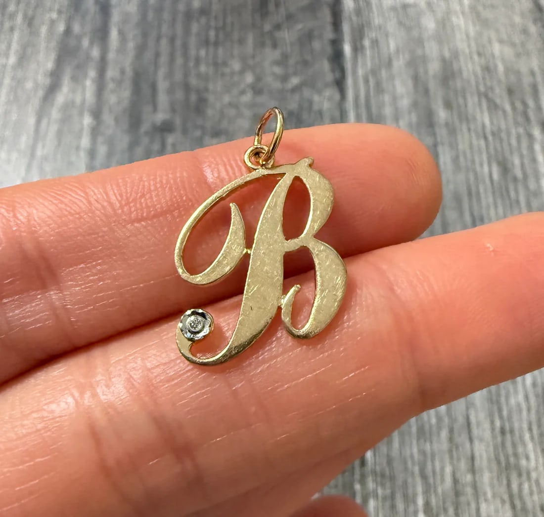 Diamond and 14K Gold Script Initial "B" Charm: Metal: 14K Yellow Gold Weight: 1.5 gramsMeasurements: 0.75 inches long by 0.65 inches wideMarkings: "BOGARZ 14K"Condition: In very good condition with some minor surface wear.
