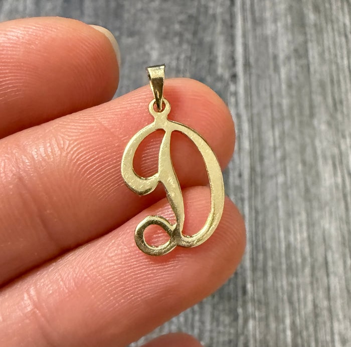 Script Initial "D" Charm in 14K Gold: A polished 14K yellow gold charm featuring an elegant, flowing script-style letter "D."