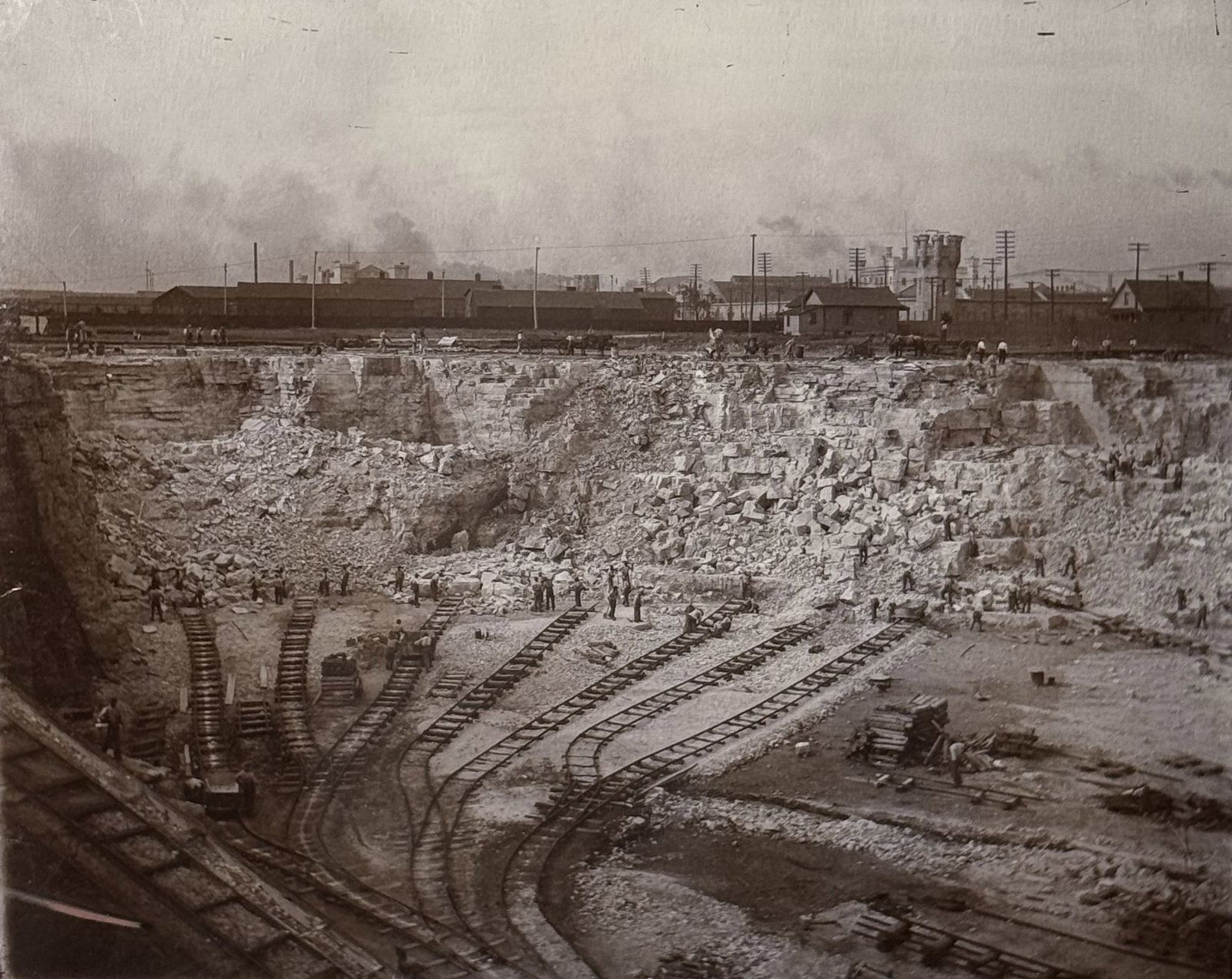 Limestone Quarry Early Industrial Quarry Photograph, Circa Early 1900s: An impressive large format original photograph documenting an early 20th century industrial quarry in full operation. The image captures workers, rail tracks, stone carts, and expansive excavation wal