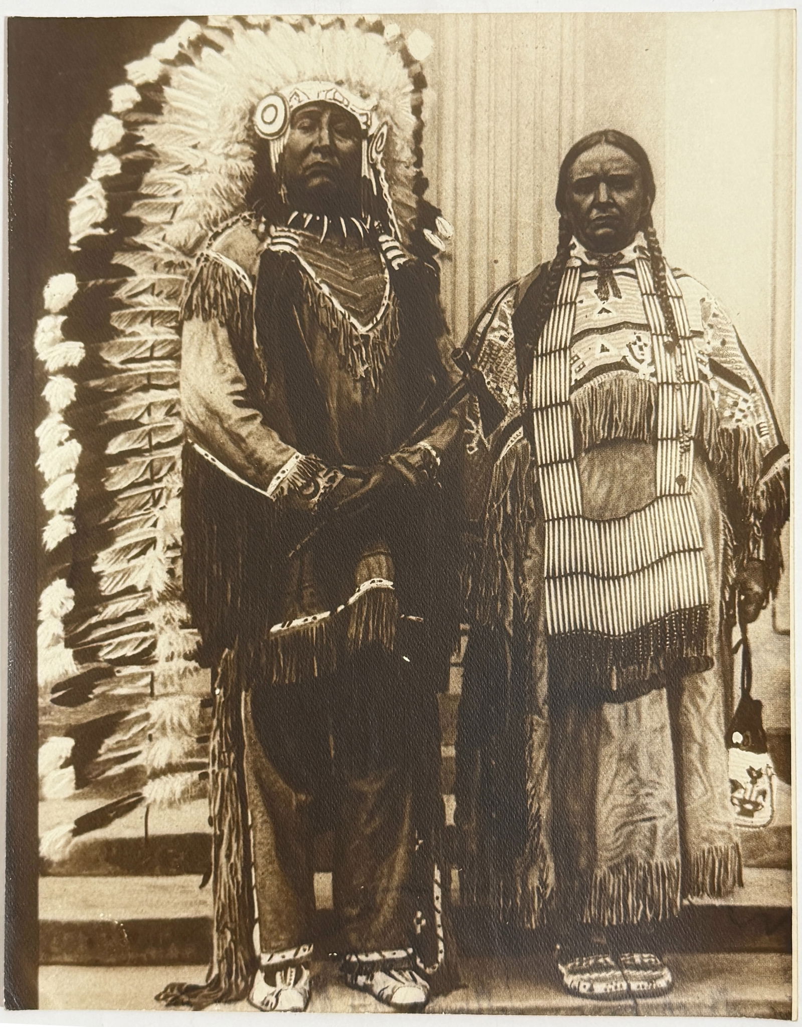 Native American Portrait Photograph: Vintage photograph depicting two Native American figures in traditional attire.