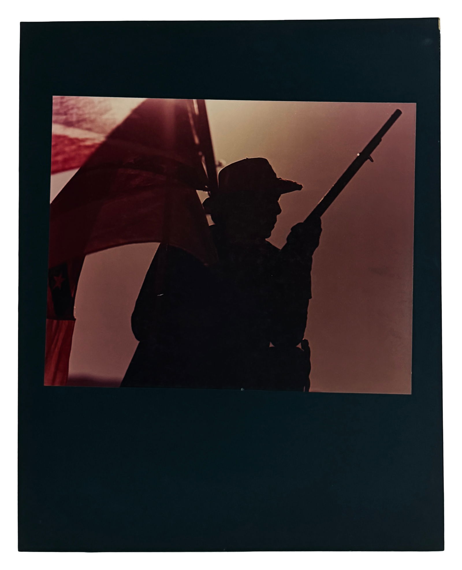 Photograph of Soldier Silhouette with Flag: Modern photographic print showing silhouette of soldier with flag; dramatic lighting.
