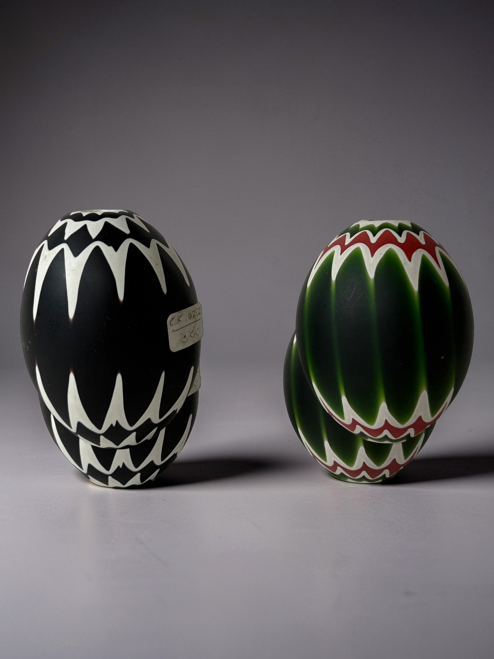 Art Chevron Beads (Pair): Pair of decorative glass objects with bold zigzag patterns in black/white and green/red.