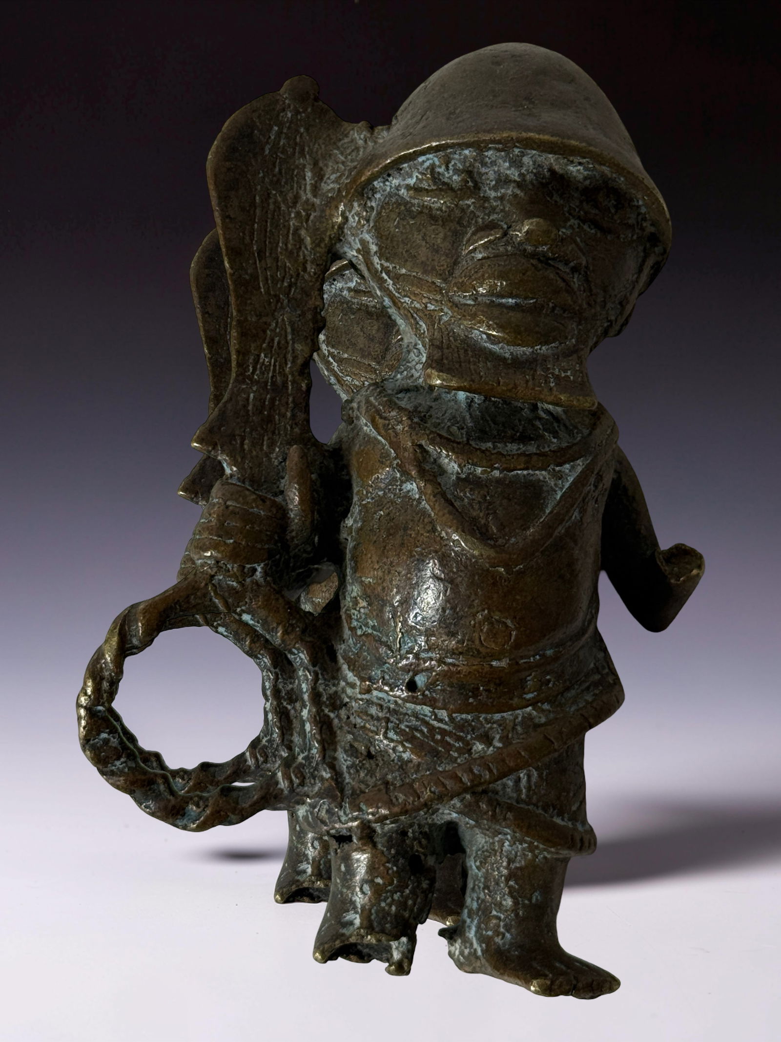 Antique African Bronze Figure: Metal figure holding object, with verdigris patina and tribal Antique African Bronze Figure.