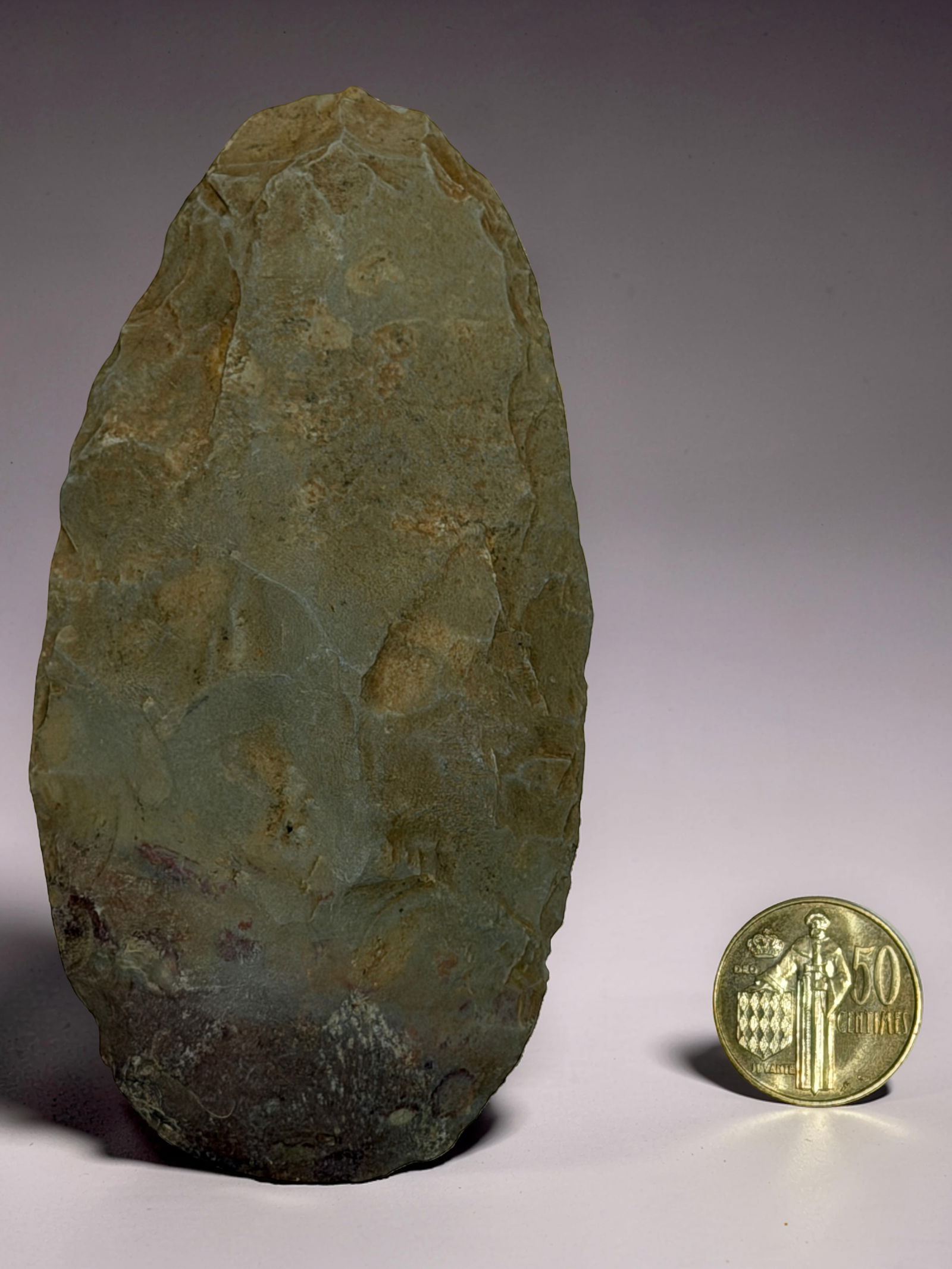 Antique Tribe Art: Knapped stone tool with green tones and visible wear.