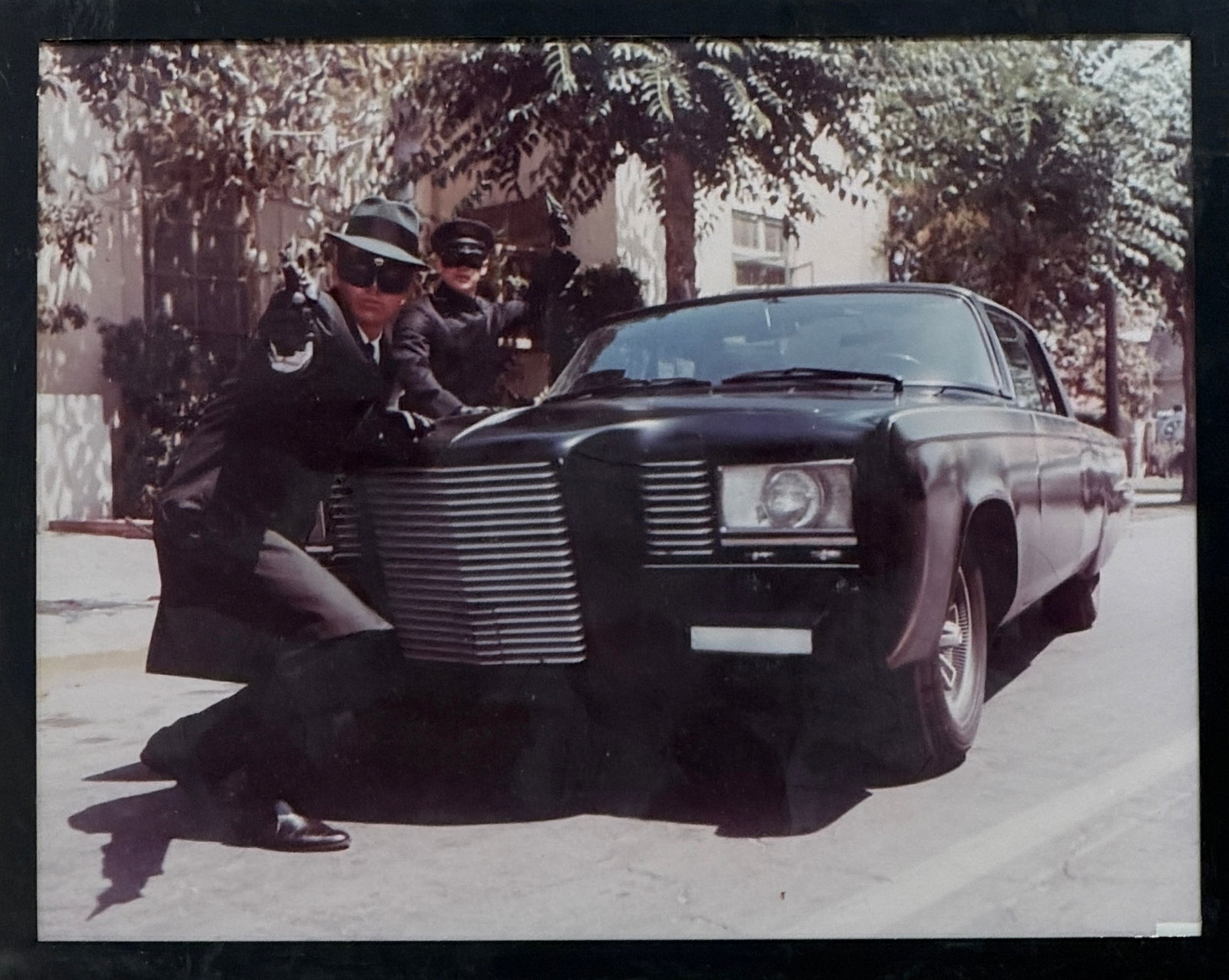 Blues Brothers Style Photograph: Photograph depicting two figures in black suits with vintage car