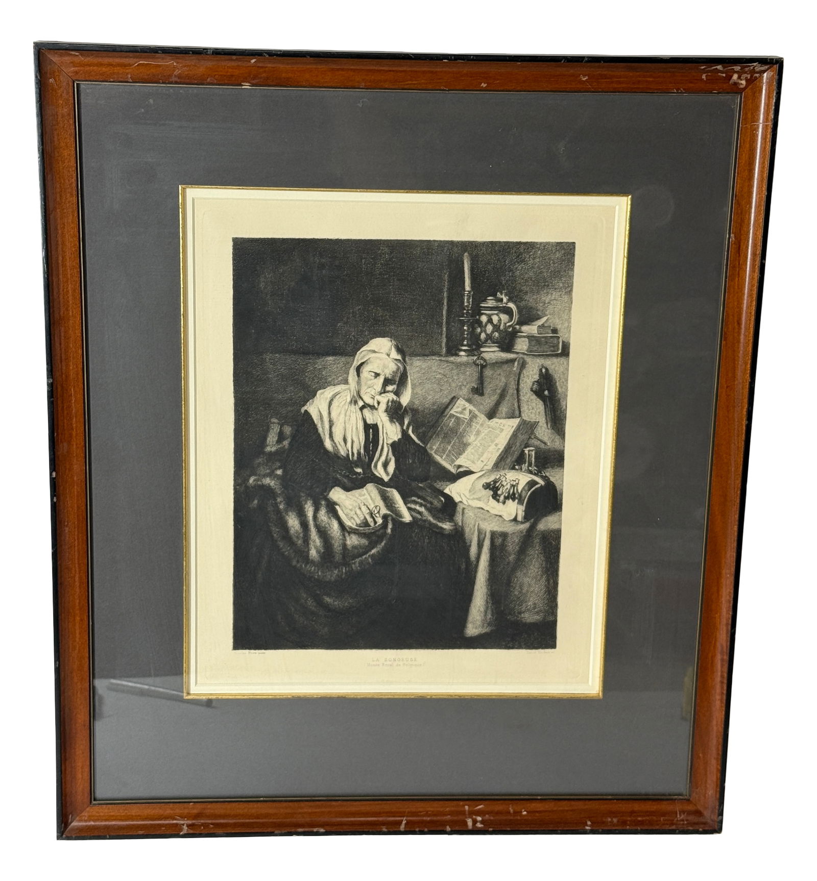Framed Etching of Seated Woman: Black and white framed etching of an elderly woman reading/sewing