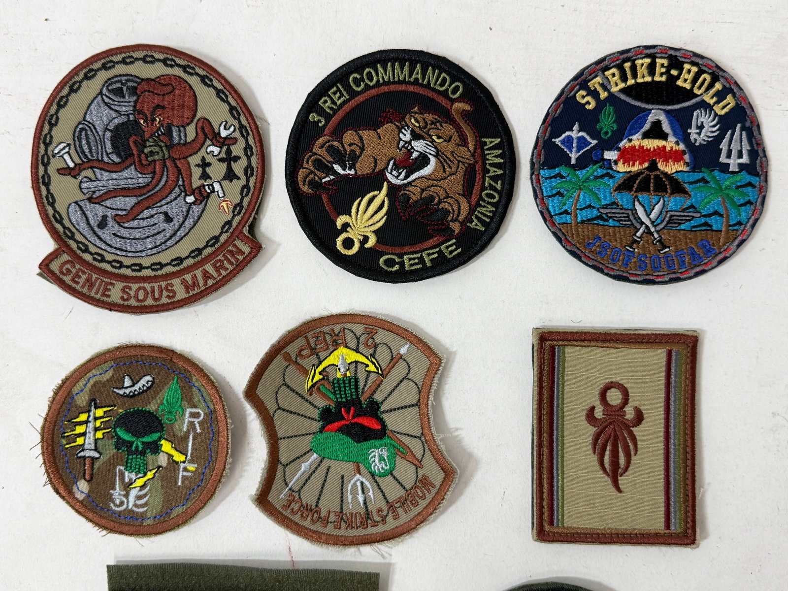 Collection of Military Embroidered Patches: Mixed lot of embroidered military and foreign legion patches, including French Foreign Legion commando units, special forces insignia, training centers, and marine units. Features various designs such