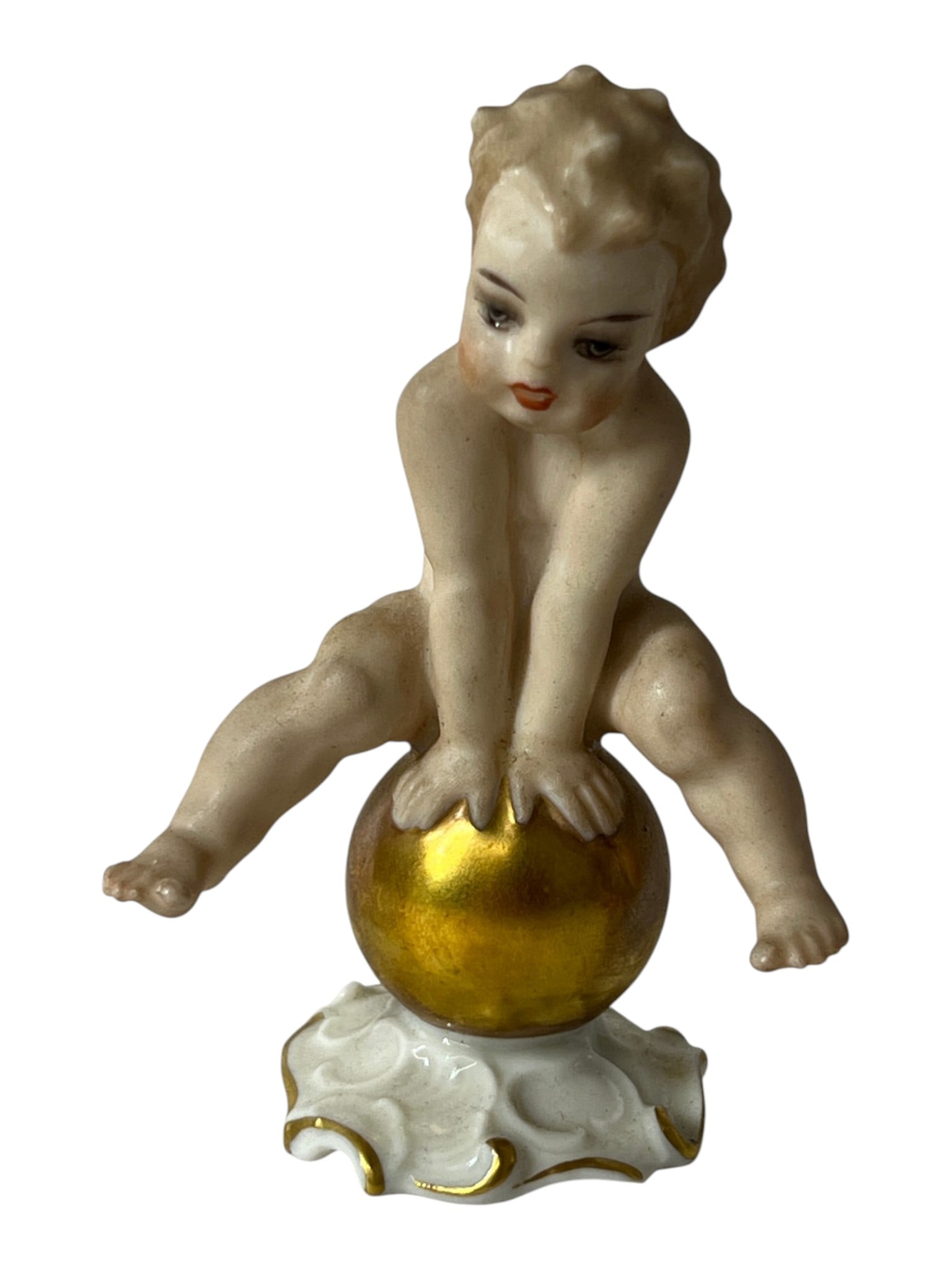 Vintage Porcelain Cherub Figurine: Small porcelain cherub figure seated on a gilt decorated ball.