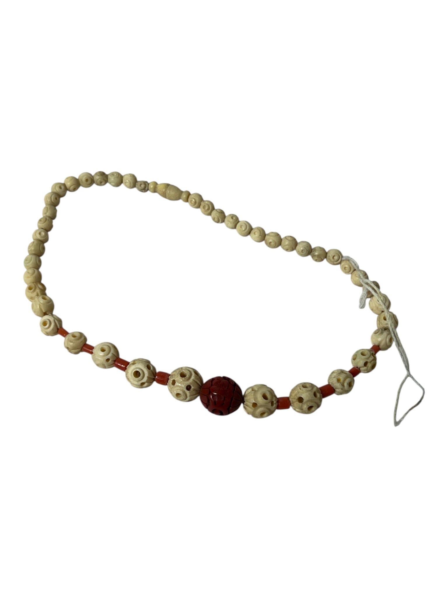 Carved Bead Necklace: Necklace composed of carved light-colored beads with red accent beads and central carved bead.